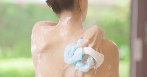 beauty woman take shower closeup of beauty girl is taking shower and wash her back with bath sponge body wash stock pictures, royalty-free photos & images